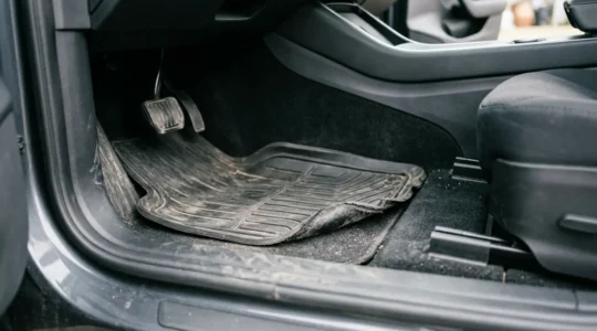 Cheap rubber floor mat sliding forward under vehicle pedals creating safety hazard