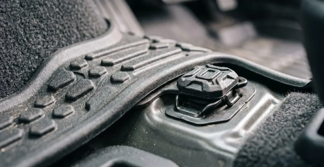 Precision-molded custom floor mat fitting exact vehicle footwell contours with retention clip integration