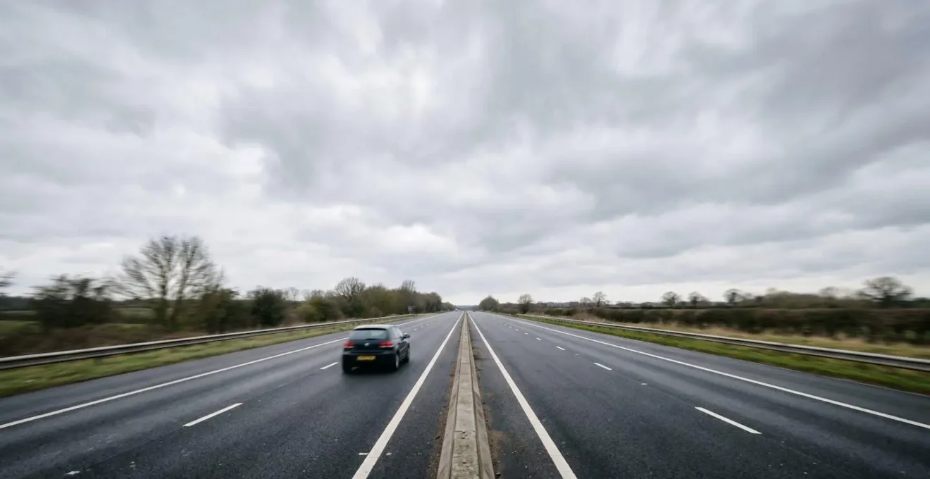 Wide environmental shot of UK motorway with motion blur suggesting high-speed travel and fuel consumption