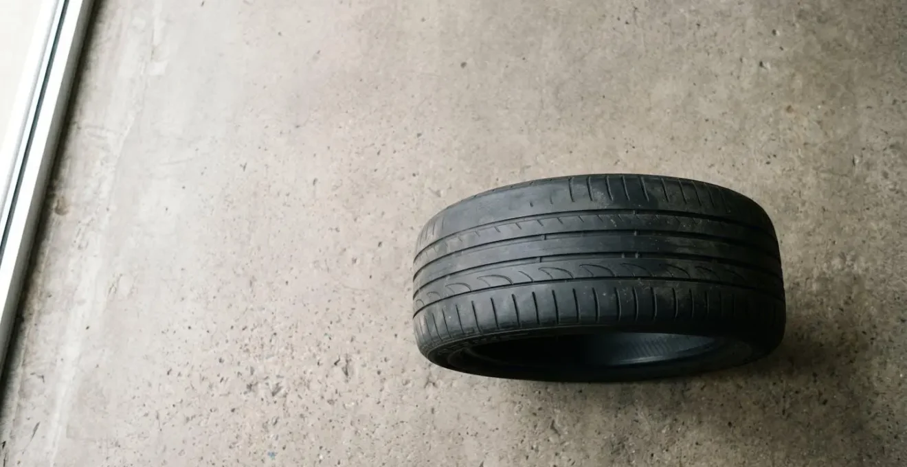 Overhead view of a car tire showing symmetrical outer shoulder wear indicating chronic under-inflation